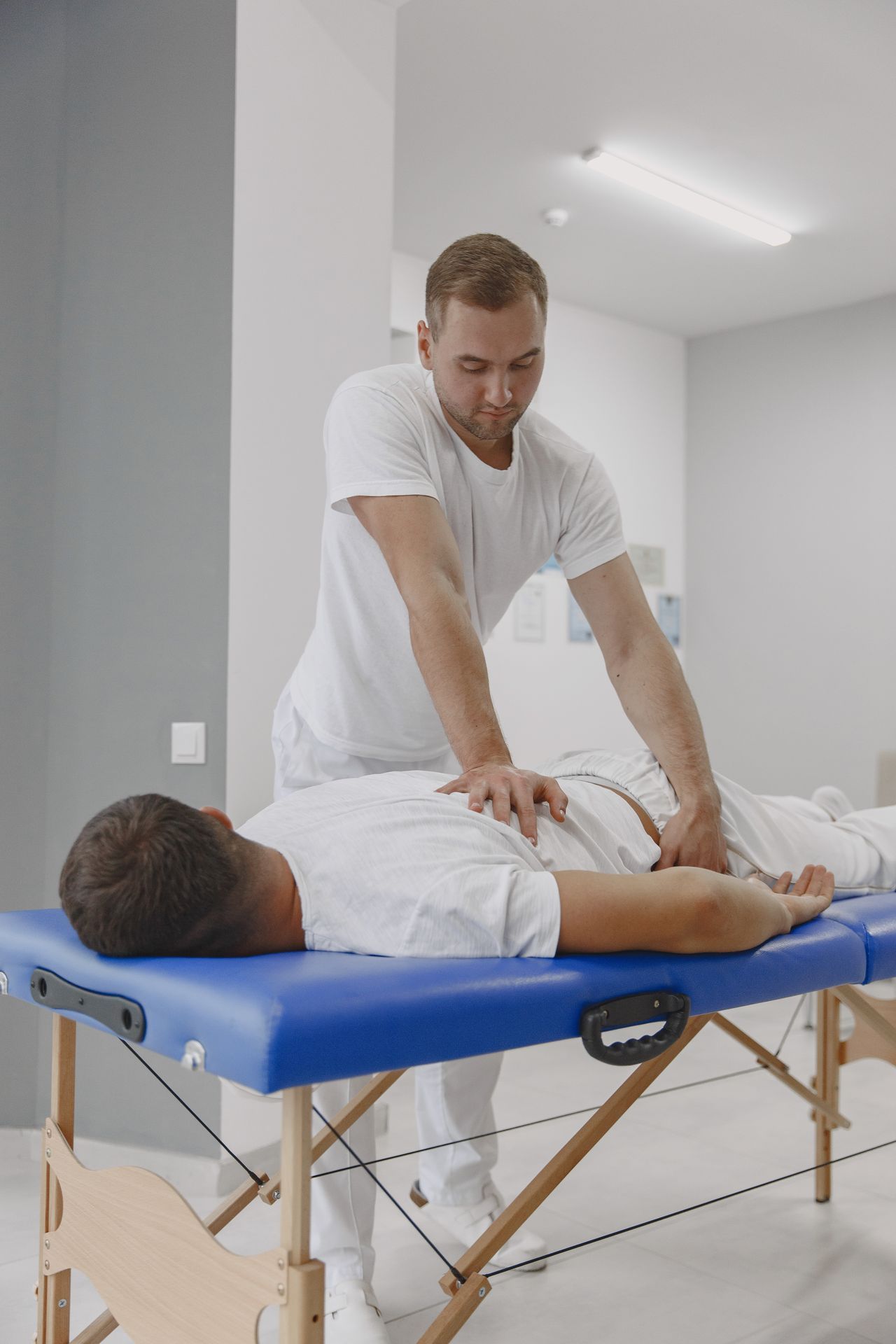 A chiropractor applying pressure to a patient's lower back during an adjustment
